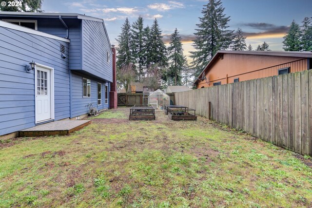 yard at dusk with an outdoor structure and a wooden deck