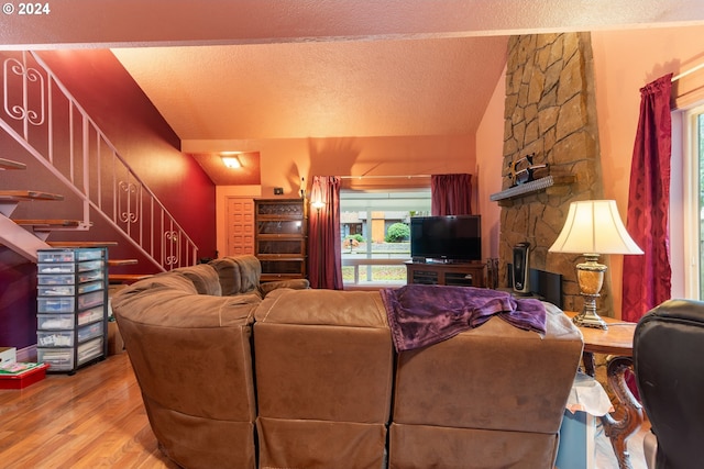 living room with hardwood / wood-style floors, a textured ceiling, vaulted ceiling, and a wealth of natural light