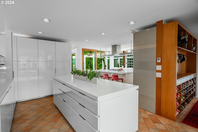 kitchen featuring light countertops, a center island, white cabinetry, and recessed lighting