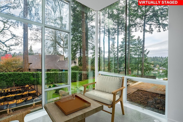 sunroom featuring a water view