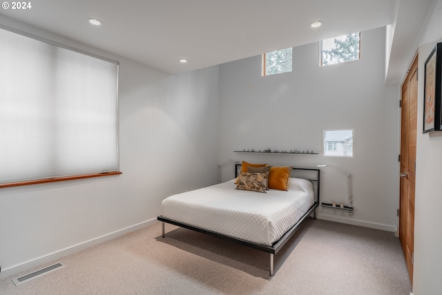 bedroom featuring radiator and light colored carpet