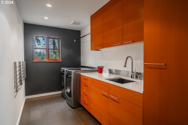 kitchen featuring sink, washer and dryer, and dark tile patterned flooring