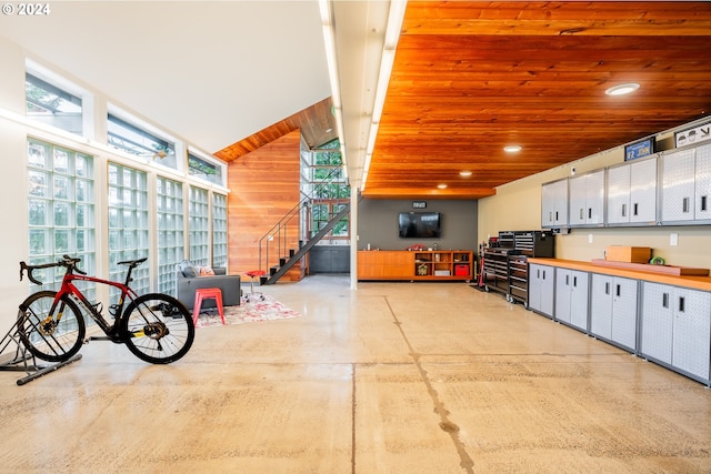 interior space featuring vaulted ceiling, wooden ceiling, and wood walls