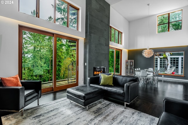 living room with a tiled fireplace and a high ceiling