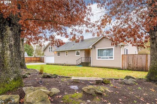 back of property featuring a yard and a garage