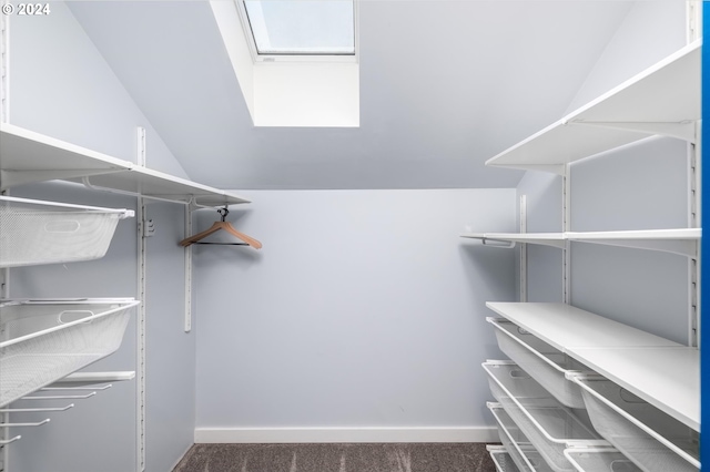 walk in closet featuring dark colored carpet and lofted ceiling