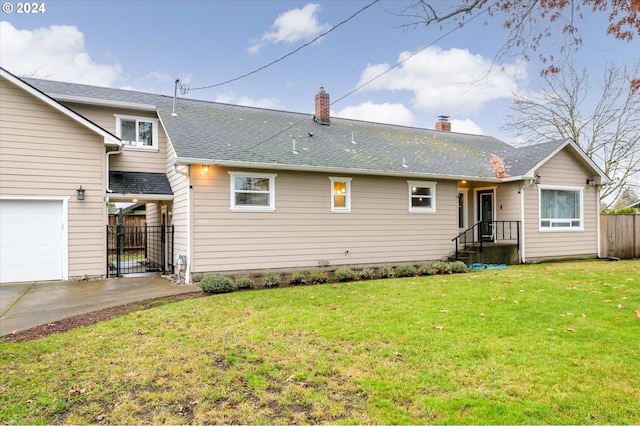 back of property featuring a lawn and a garage