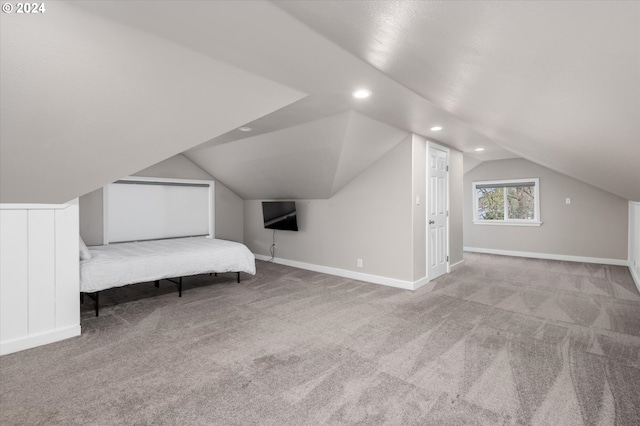 unfurnished bedroom with light colored carpet and vaulted ceiling