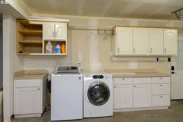 laundry room featuring washer and dryer and cabinets