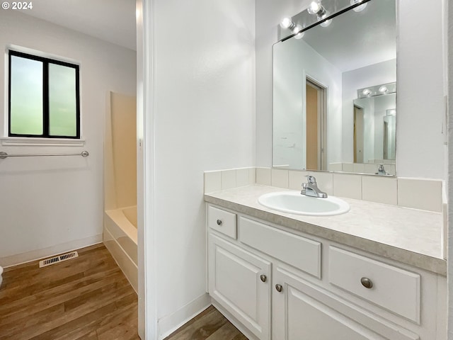 bathroom featuring vanity, bathing tub / shower combination, and hardwood / wood-style floors