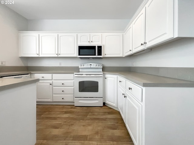 kitchen featuring dark wood-type flooring, white appliances, and white cabinets