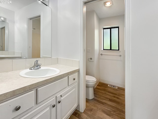 bathroom featuring vanity, toilet, and wood-type flooring