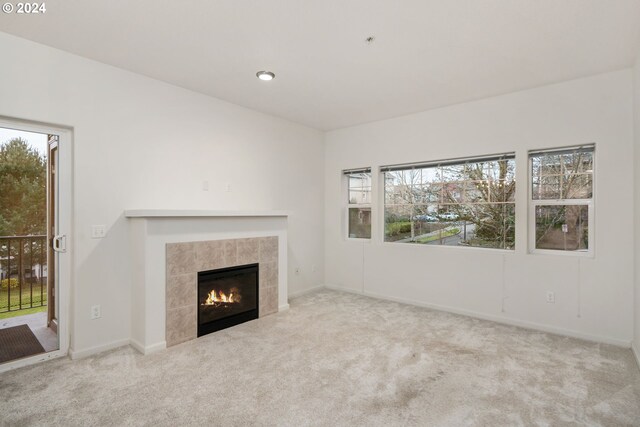 unfurnished living room featuring light carpet, a baseboard heating unit, and a notable chandelier