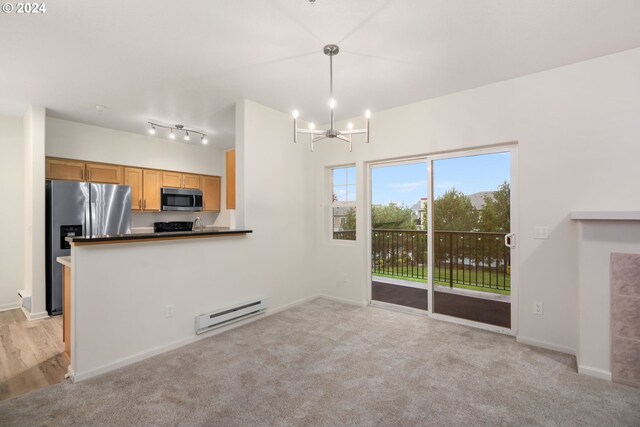 unfurnished living room featuring light carpet, baseboard heating, sink, a tile fireplace, and an inviting chandelier