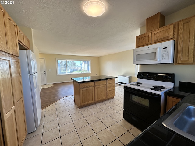 kitchen featuring a textured ceiling, light hardwood / wood-style flooring, sink, and white appliances