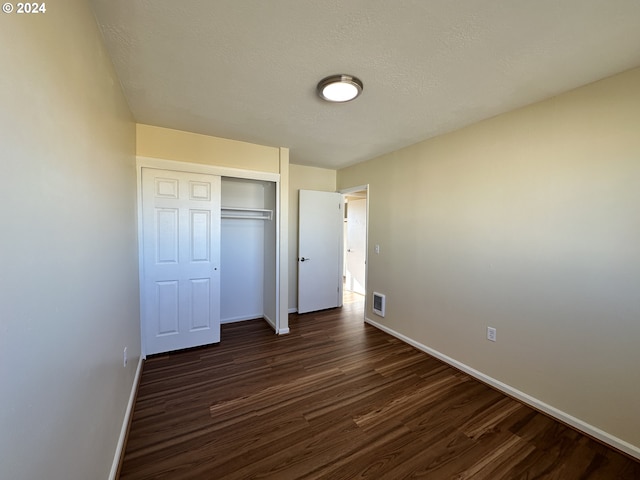 14865 Mt View Dr, Condon, OR 97823 - unfurnished bedroom with dark wood finished floors, a textured ceiling, a closet, visible vents, and baseboards