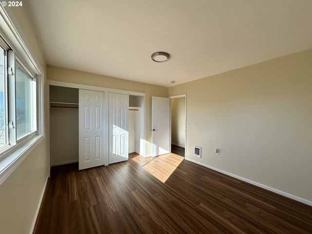 14865 Mt View Dr, Condon, OR 97823 - unfurnished bedroom featuring dark wood-style flooring, baseboards, multiple closets, and visible vents