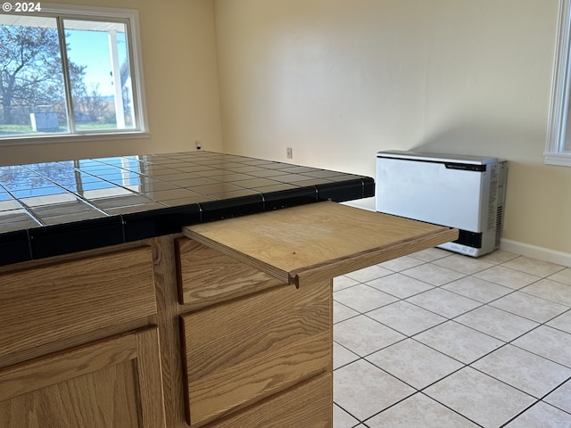 14865 Mt View Dr, Condon, OR 97823 - kitchen featuring light tile patterned floors, baseboards, brown cabinetry, and tile counters