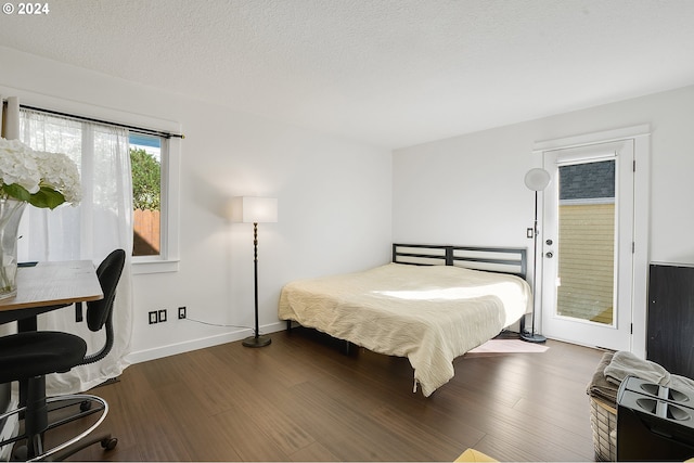 bedroom featuring a textured ceiling and dark wood-type flooring