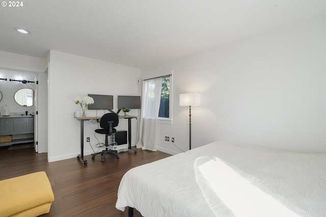 bedroom with dark hardwood / wood-style floors and ensuite bath