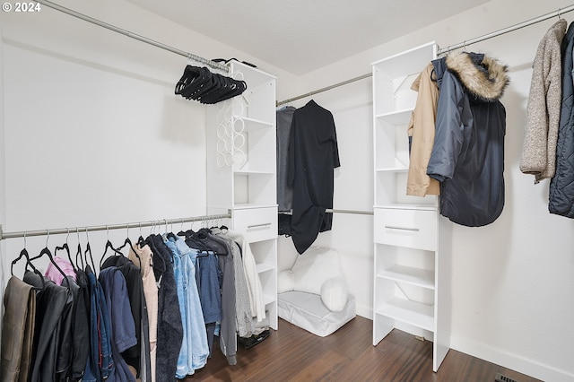 walk in closet with dark hardwood / wood-style flooring