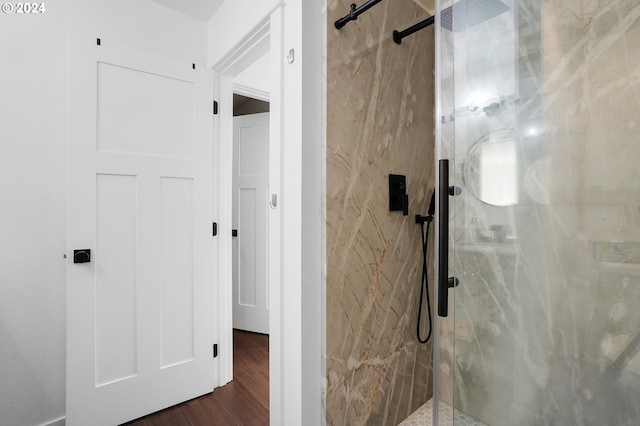 bathroom with hardwood / wood-style flooring and a shower with door