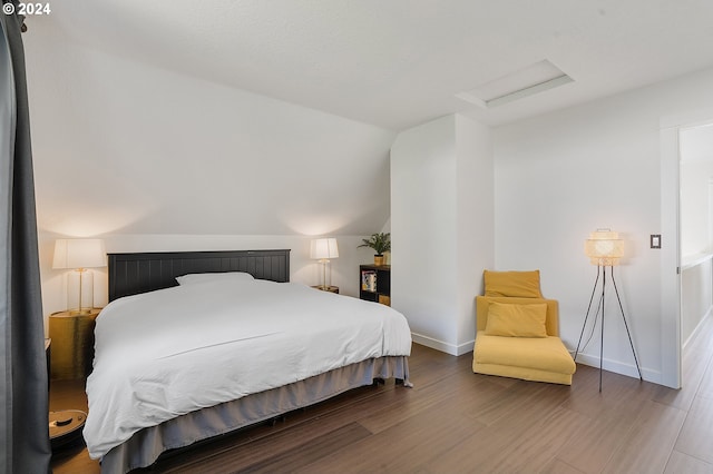 bedroom with vaulted ceiling and wood-type flooring