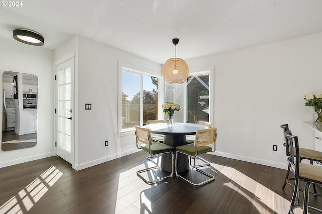 dining space with dark hardwood / wood-style flooring and a textured ceiling