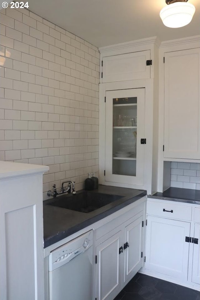 kitchen with sink, white cabinets, white dishwasher, and decorative backsplash