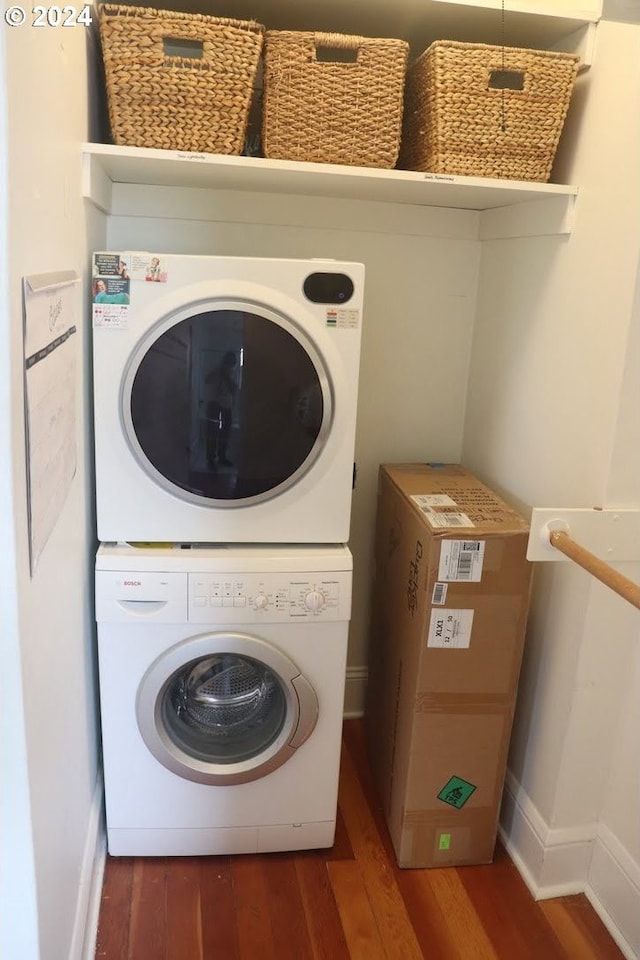 laundry room with stacked washing maching and dryer and dark hardwood / wood-style floors