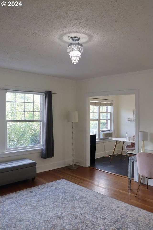 interior space with a notable chandelier, a textured ceiling, cooling unit, and dark hardwood / wood-style floors