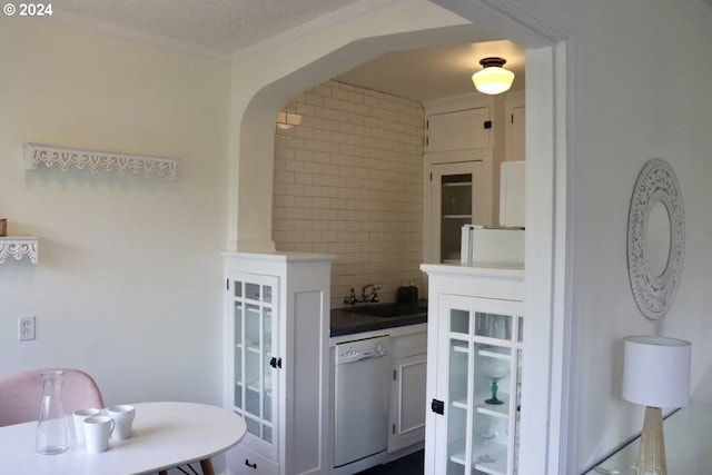 interior space featuring dishwasher, backsplash, ornamental molding, and sink