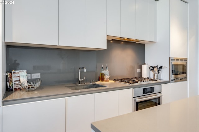 kitchen with white cabinets, appliances with stainless steel finishes, and sink