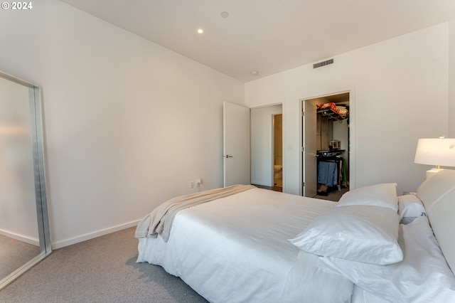 bedroom featuring a spacious closet, light colored carpet, and a closet