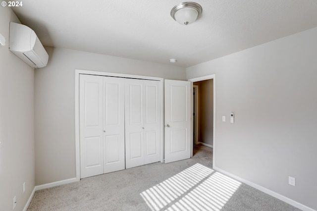 unfurnished bedroom featuring light carpet, a closet, and a wall mounted air conditioner