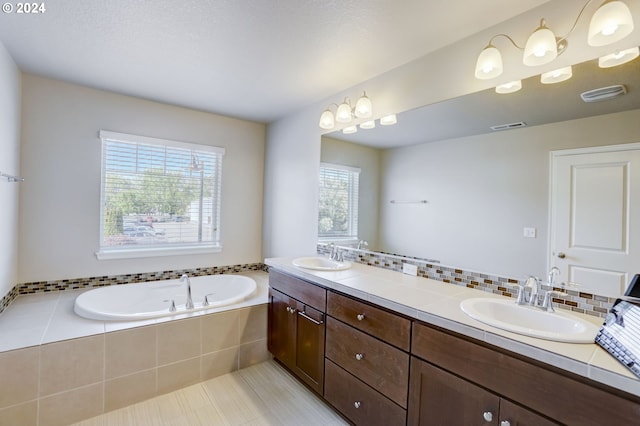 bathroom with tiled bath, tile flooring, and double sink vanity