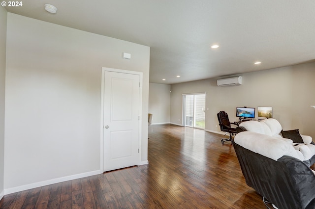 sitting room featuring a wall mounted air conditioner and dark hardwood / wood-style flooring