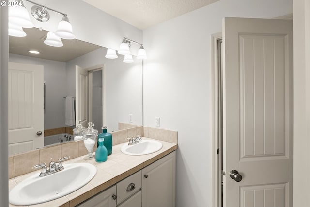 bathroom featuring double vanity and a bathtub