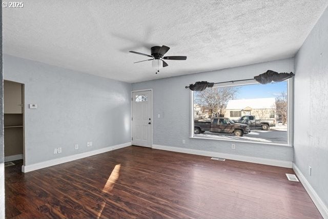 spare room with dark wood-type flooring, a textured ceiling, and ceiling fan