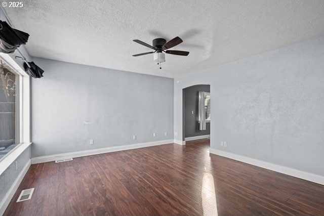 spare room featuring ceiling fan, dark hardwood / wood-style floors, and a textured ceiling