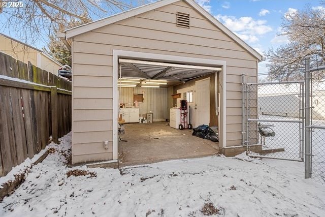 snow covered structure featuring a garage