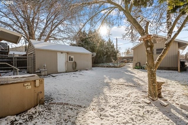 yard layered in snow with an outbuilding