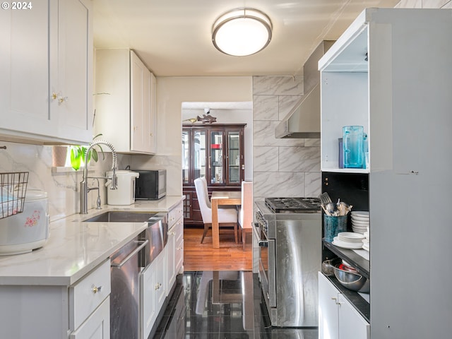 kitchen with white cabinets, light stone counters, stainless steel appliances, and tasteful backsplash