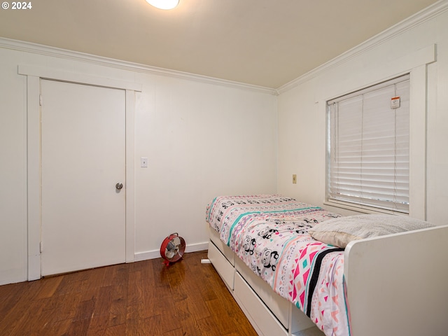 bedroom with ornamental molding and dark hardwood / wood-style flooring