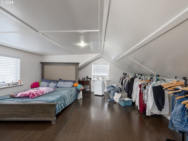 bedroom featuring multiple windows, dark hardwood / wood-style floors, lofted ceiling, and wood walls