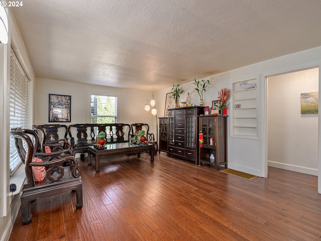 living room with a textured ceiling, an inviting chandelier, and hardwood / wood-style floors