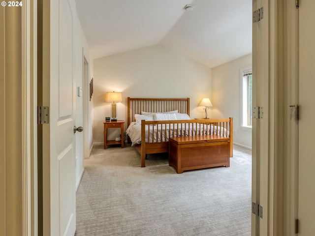 carpeted bedroom featuring baseboards and vaulted ceiling