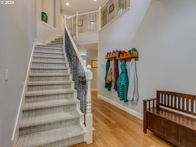 stairway featuring hardwood / wood-style floors and a high ceiling