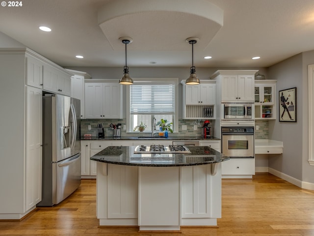 kitchen featuring a kitchen island, a sink, light wood-style floors, white cabinets, and appliances with stainless steel finishes