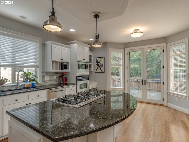 kitchen with a healthy amount of sunlight, light wood-style flooring, appliances with stainless steel finishes, and a sink